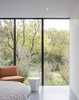 Modern home with Ceiling Lighting, Chair, Dark Hardwood Floor, and Recessed Lighting. Within each bedroom, the architecture acts as a frame to the landscape beyond. The opening picture faces east towards the land and water conservation project across the street; it is 10' h x 15' w. Photo 11 of The Winnwood Residence