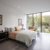 Modern home with Dark Hardwood Floor, Recessed Lighting, and Ceiling Lighting. Within each bedroom, the architecture acts as a frame to the landscape beyond. The opening picture faces east towards the land and water conservation project across the street; it is 10' h x 15' w. The colors within each bedroom were selected to compliment the species of plants outside the home. Photo 15 of The Winnwood Residence