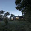 Modern home with Outdoor, Grass, Trees, Gardens, Front Yard, and Shrubs. Viewed from the street looking west, the first third of the lot was landscaped to be an extension of the adjacent land and water conservation project and to provide an undisturbed animal habitat. Photo 3 of The Winnwood Residence