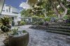 Modern home with Outdoor, Hardscapes, Front Yard, Walkways, Trees, Stone Patio, Porch, Deck, Raised Planters, Concrete Patio, Porch, Deck, Flowers, Landscape Lighting, Shrubs, and Large Patio, Porch, Deck. Front courtyard sets a peaceful ambiance around the home Photo 6 of Nuuanu Heritage Estate