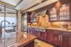 Modern home with Kitchen, Range, Wood Cabinet, Stone Slab Backsplashe, Refrigerator, Drop In Sink, Recessed Lighting, Dark Hardwood Floor, Range Hood, and Granite Counter. Chef's kitchen features Subzero and Wolf appliances, and Bordeaux granite. Photo 6 of Hawaii Architect's Home in Keauhou Estates