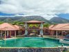 View of pool and waterfall with the Maui mountain range in the distance. Photo 4 of Launiupoko Luxury Estate modern home