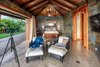 Modern home with Bedroom, Chair, Bed, Limestone Floor, and Ceiling Lighting. One of three master bedrooms. Note the pocket doors retract to blend indoor/outdoor living space. Photo 9 of Launiupoko Luxury Estate