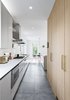 Modern home with Kitchen, White Cabinet, Microwave, Dishwasher, Range Hood, Ceiling Lighting, Engineered Quartz Counter, Cooktops, Refrigerator, Light Hardwood Floor, Porcelain Tile Floor, Accent Lighting, Ceramic Tile Backsplashe, Undermount Sink, and Pendant Lighting. Kitchen Photo 3 of The Rockcliffe Renovation