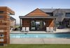 Modern home with Exterior, House Building Type, Gable RoofLine, Wood Siding Material, and Metal Roof Material. The media room spills out onto the patio and pool. Photo of Renton Hill House