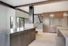 Modern home with Kitchen, Metal Cabinet, and Ceramic Tile Floor. A dual-sided tv is hidden in the custom blackened steel casing. Photo 12 of Renton Hill House