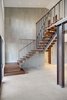 Modern home with Staircase, Metal Railing, and Wood Tread. A floating wood and steel stair leads up to the second level. Photo 17 of Renton Hill House