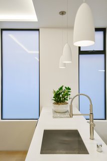 Tinted glass windows protect this white kitchen's luminous sheen.