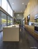 Modern home with Kitchen, Microwave, Cooktops, Metal Counter, Range Hood, Dishwasher, Pendant Lighting, Refrigerator, Wood Cabinet, Wall Oven, Undermount Sink, Glass Tile Backsplashe, and Concrete Floor. Lofted kitchen, sealed integrally colored concrete floors. The tiny frosted glass window only glows on owners' marriage anniversary for 2 minutes. Photo 6 of Essence of the Desert