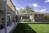 Modern home with Exterior, Flat RoofLine, House Building Type, and Concrete Siding Material. Main house patio connecting to Guest house patio. The both meet at the entry courtyard to the Guest house. The notch in the masonry fence wall receives the setting sun of the owners' marriage anniversary. Photo 10 of Essence of the Desert