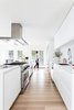 Modern home with Kitchen, Light Hardwood Floor, Dishwasher, Undermount Sink, Stone Slab Backsplashe, Range, Engineered Quartz Counter, Refrigerator, Range Hood, and White Cabinet. The design studio, Studio Block, strives for their work to be "enduring and uncomplicated, modern yet warm, and embracing simple luxury with playful moments."
Photo 5 of The Kylo House