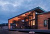 Modern home with Exterior, House Building Type, Glass Siding Material, Shed RoofLine, Wood Siding Material, Metal Siding Material, and Metal Roof Material. A large window wall folds in to create a spacious deck that wraps up and over to become the roof and overhang of the home. Photo of Estes Park Residence