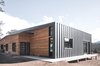 Modern home with Exterior, Wood Siding Material, House Building Type, Metal Siding Material, Shed RoofLine, and Metal Roof Material. A standing seam metal roof wraps down the exterior wall of the home to protect against the harsh winds of the terrain. Photo 8 of Estes Park Residence