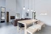 Modern home with Dining Room, Chair, Ceiling Lighting, Wood Burning Fireplace, Table, and Concrete Floor. The open area of the first floor with the fireplace and a massive sectionnal sofa is the perfect after-ski get together area, Photo 2 of Villa Boréale
