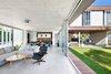 Modern home with Living Room, Concrete Floor, Table, Ceiling Lighting, Ottomans, Pendant Lighting, Coffee Tables, and Sofa. Living room, dinig room and open kitchen connecting to the outdoors Photo of House KI