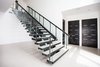 Custom metal fabrication with glass railing on these stairs echo the clean, modern look that emanates throughout the home. Photo 13 of Purple Sage modern home