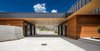 Modern home with Exterior, Flat RoofLine, House Building Type, Metal Siding Material, Wood Siding Material, Metal Roof Material, and Stone Siding Material. Wide open parking outside the sleek breezeway. Photo 5 of Purple Sage