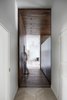 Modern home with Dark Hardwood Floor and Light Hardwood Floor. A “hidden” door to the laundry room lies along the walnut wall on one side of the hallway. Photo 12 of Interior KG