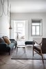 Modern home with Living Room, Pendant Lighting, Medium Hardwood Floor, Chair, Coffee Tables, Ottomans, Sofa, and Rug Floor. Prominent windows provide views of the surrounding cityscape and plenty of natural light. Photo 3 of Interior KG