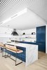 Modern home with Kitchen, Marble Backsplashe, Light Hardwood Floor, Ceiling Lighting, Cooktops, Refrigerator, Marble Counter, Colorful Cabinet, Wall Oven, and Drop In Sink. Kitchen Floating Steel Shelves and metal inlay on surrounding walls - Robert wanted a minimal kitchen. We passed on upper cabinets and opted for sleek floating metal shelves that wrapped around the walls with a 1/4" metal inlay on the surrounding walls. The metal perfectly complimented the already industrial feel of the unit. Photo 5 of Seaholm Custom Condo