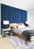 Modern home with Bedroom, Bed, Light Hardwood Floor, Night Stands, Storage, Lamps, and Shelves. Wall panels in master bedroom - We had a local upholsterer create these custom wall panels in a blue mohair in the master bedroom to add warmth & texture to the space, again bringing back in the Hague Blue. Photo 8 of Seaholm Custom Condo