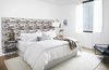 Modern home with Bedroom, Rug Floor, Light Hardwood Floor, Lamps, Bed, Chair, Table Lighting, and Night Stands. The guest bedroom has a wall-mounted headboard, metal night stand and white bedding with a camel throw blanket, accented with a dark teal armchair. Photo 14 of Seaholm Custom Condo