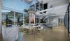 Modern home with Dining Room, Chair, Table, Light Hardwood Floor, Ceiling Lighting, and Medium Hardwood Floor. Day Time Main level staircase and dining area of our Magnificent Cantilever Home Photo 19 of Magnificent Cantilever Home For Ocean View Living