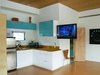 Modern home with Kitchen, Wood Counter, Colorful Cabinet, Refrigerator, Microwave, Cooktops, Undermount Sink, White Cabinet, Ceiling Lighting, Accent Lighting, Wood Backsplashe, Cork Floor, and Glass Tile Backsplashe. Kitchenette Photo 8 of Modern Studio - Pet Friendly