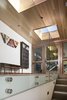 Modern home with Staircase. The glass lined stairway leads up from the lower level to the entry on the main floor. Photo 9 of Rustic Meets Modern