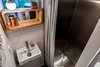 Modern home with Bath Room, Wall Lighting, One Piece Toilet, Open Shower, Full Shower, and Wall Mount Sink. Tru Form Tiny custom makes all their stainless steel showers. Photo 6 of This Custom Tiny Home Has a Clever, Space-Saving Elevator Bed