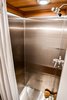 Modern home with Bath Room, Metal Wall, Full Shower, and Open Shower. Stainless steel shower. Photo 7 of Not So tiny Tiny, for a Doctor in California