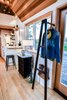 Modern home with Storage Room and Closet Storage Type. A custom coat rack at the entrance maintains the open feel. Photo 8 of This Custom Tiny Home Has a Clever, Space-Saving Elevator Bed