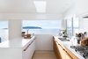 Modern home with Kitchen, Recessed Lighting, Engineered Quartz Counter, Range, Wood Cabinet, Subway Tile Backsplashe, Drop In Sink, Light Hardwood Floor, and Range Hood. A young Vancouver family asked Falken Reynolds Interiors to convert their waterfront vacation home on British Columbia’s Sunshine Coast into their primary residence. To facilitate livability for the foursome, an enlarged kitchen, complete with a large white island with wood hardware, was a major part of the renovation. Photo 4 of Halfmoon Bay House