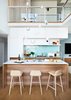 Modern home with Kitchen, Wood Cabinet, Refrigerator, Glass Tile Backsplashe, Wall Oven, Pendant Lighting, Undermount Sink, Engineered Quartz Counter, Medium Hardwood Floor, Cooktops, Range Hood, and White Cabinet. Nerd Stools by Muuto Photo of Beatty Street Loft