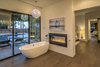 Modern home with Bath Room, Full Shower, Ceiling Lighting, Drop In Sink, Enclosed Shower, Corner Shower, Soaking Tub, Freestanding Tub, Medium Hardwood Floor, One Piece Toilet, Wall Lighting, Accent Lighting, and Granite Counter. Master Bath Soaking Tub By The Fire with Walls of Glass Overlooking Pool Area Photo 5 of The Allen House