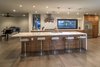 Modern home with Kitchen, Wood Cabinet, Range, Refrigerator, Dishwasher, Cooktops, Microwave, Drop In Sink, Range Hood, Pendant Lighting, Medium Hardwood Floor, Ceiling Lighting, and Granite Counter. Modern Kitchen with Oversized Center Island Open to Dining and Great Room Areas with Pass-Through Serving Window to Pool Area for Entertaining Photo 9 of The Allen House