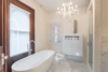Modern home with Bath Room, Ceiling Lighting, Freestanding Tub, and Enclosed Shower. The master bath has white marble flooring with a large soaker tub, walk in shower and mother of pearl tile surround. The vanity has a white quartz top with crystal handles on the faucets. Photo 8 of The Empress
