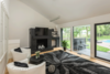 Modern home with Living Room. The fireplace area is opposite the kitchen with vaulted ceiling, large glass windows, cylindrical crystal lighting and a glass door walk out to the pool area. Photo 10 of The Empress
