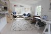 Modern home with Living Room, Coffee Tables, Ceiling Lighting, Sofa, Chair, Light Hardwood Floor, Ottomans, Floor Lighting, Recliner, Bookcase, and Wall Lighting. Living room Photo 10 of The Litwood House