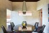 Modern home with Dining Room, Table, Chair, and Ceiling Lighting. One striking feature is the window cutouts that forego glass and screens, instead using tile from the roof to allow for airflow and an interesting aesthetic. Photo 12 of Live inspired in this Japanese Musician's midcentury indoor/outdoor home asking $2.95 million