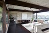 Modern home with Living Room, Chair, Sectional, Ceiling Lighting, Bench, Sofa, and End Tables. Owner Ryuichi Sakamoto found inspiration in the naturally aging piano left behind by Sid Snyder, and specifically chose not to tune the piano. Photo 17 of Live inspired in this Japanese Musician's midcentury indoor/outdoor home asking $2.95 million