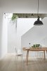 Modern home with Dining Room, Lamps, Chair, Table, Medium Hardwood Floor, and Ceiling Lighting. A new staircase and roof light, brings natural light into the dining area, overlooked by the kitchen above Photo 3 of Hackney Mews House