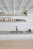 Modern home with Kitchen, Wood Counter, Wood Cabinet, Drop In Sink, White Cabinet, Concrete Counter, Mirror Backsplashe, and Ceramic Tile Backsplashe. Bespoke joinery, tiled finishes, concrete tops and high-level mirrors to the kitchen Photo 7 of Hackney Mews House