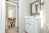 Modern home with Office, Light Hardwood Floor, Desk, and Chair. A small desk is tucked away near the combo washer and dryer. Photo 4 of Saltbox Tiny Home