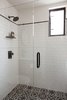 Modern home with Bath Room, One Piece Toilet, Wall Lighting, Undermount Sink, Enclosed Shower, Ceramic Tile Wall, Tile Counter, and Porcelain Tile Floor. The walls use white subway tiles with black accent trim molding, and the floor features decorative artisan glazed tiles with raised surface patterns. Photo 8 of Normal Heights Residence