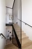 Modern home with Staircase, Wood Tread, and Metal Railing. The stairway showcases a guardrail with long, custom-made stair rods, which start from the basement and reach the second-floor ceiling. Photo 17 of Normal Heights Residence