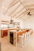 Modern home with Kitchen, Cooktops, Track Lighting, Ice Maker, Mosaic Tile Backsplashe, Range Hood, Wall Oven, Wood Cabinet, Wine Cooler, Beverage Center, Porcelain Tile Floor, Dishwasher, Microwave, Mirror Backsplashe, Ceiling Lighting, Refrigerator, and Undermount Sink. We found these amazing ceilings hidden behind a false drywall cove ceiling in the remodel Photo 12 of Casa Ilios (Seven Bedrooms)