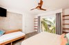 Modern home with Bedroom, Bed, Wall Lighting, Concrete Floor, Shelves, and Ceiling Lighting. Upstairs bedroom with Costa Rican Laurel wood furniture -- and a daybed we designed Photo 11 of Casa Ilios (Seven Bedrooms)
