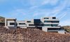 Modern home with Exterior, Concrete Siding Material, Metal Siding Material, Metal Roof Material, House Building Type, Flat RoofLine, and Stucco Siding Material. Shot with a long lens a street away. Side profile Photo 8 of The Huhn House