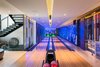 Modern home with Living Room, Medium Hardwood Floor, Ceiling Lighting, Recessed Lighting, and Wall Lighting. Bowling alley, bar, theater and chilled wine storage Photo 5 of The Huhn House